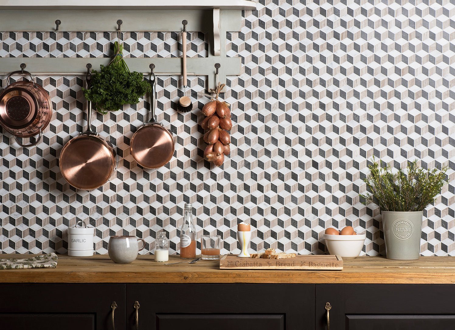 Copper frying pans hanging from a wooden rack showcasing kitchen backsplash ideas with warm metallic cookware