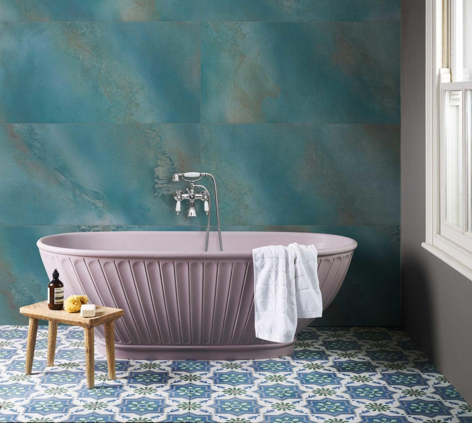 Lavender freestanding bathtub with vertical ribbed design and chrome faucet in a bathroom tile ideas article.