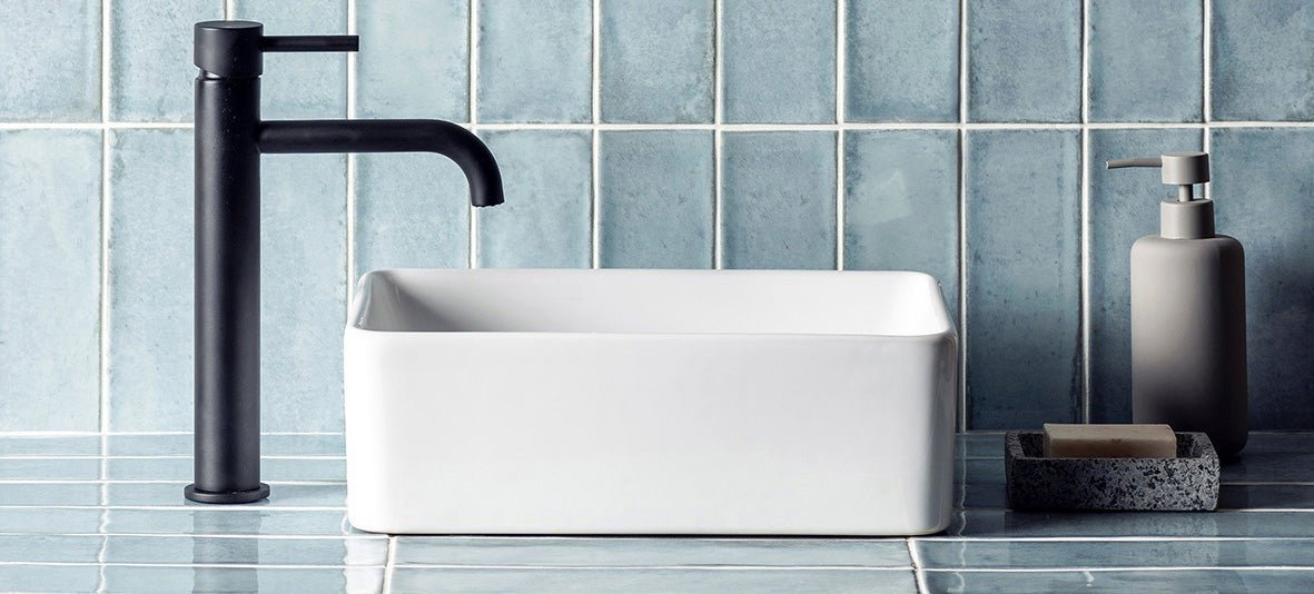 Black matte faucet with sleek modern design beside white rectangular ceramic sink for elevated interior design feature wall tiles