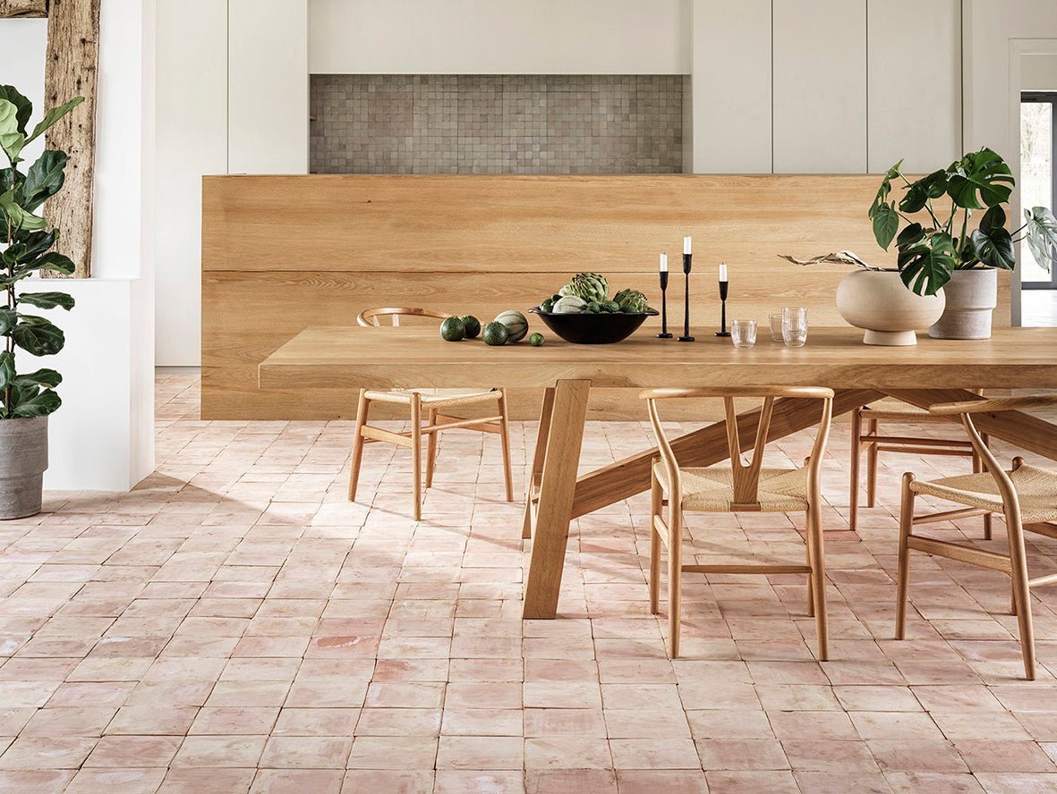 Light wood dining table with sleek minimalist design and sturdy legs featured in terracotta tile selection article.