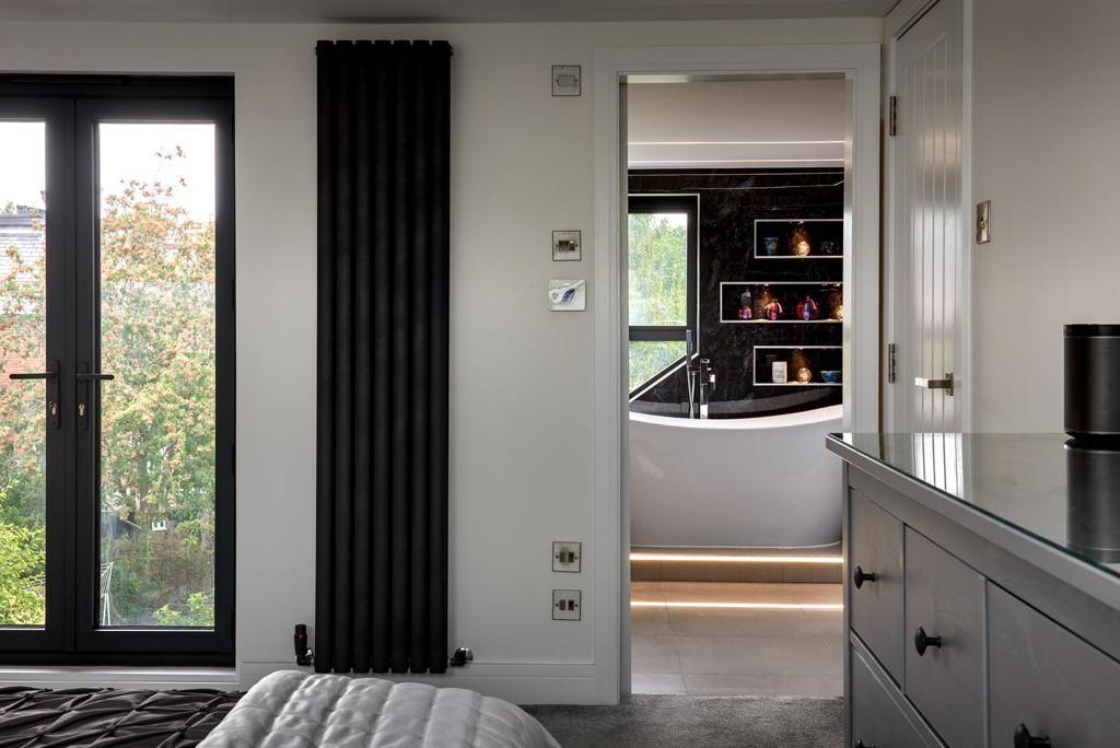 Black vertical radiator with sleek modern design and matte finish featured in mandys bathroom design makeover