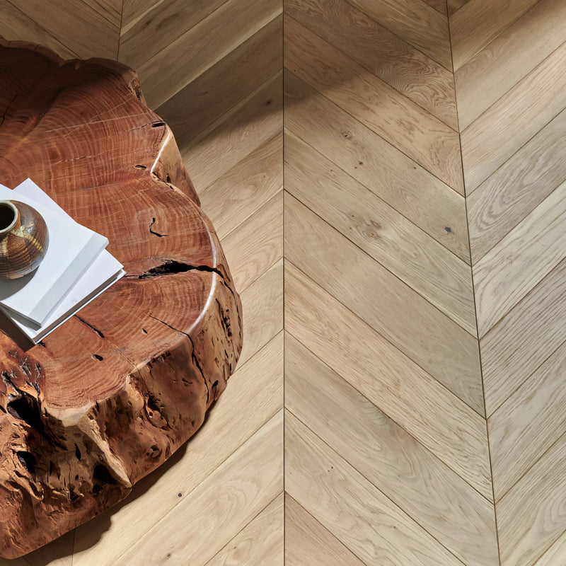Natural wood chevron wood flooring with a warm light brown finish and visible grain pattern.