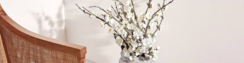 A delicate arrangement of white blossoms in a textured gray ceramic vase from cream paint and neutral paint collection
