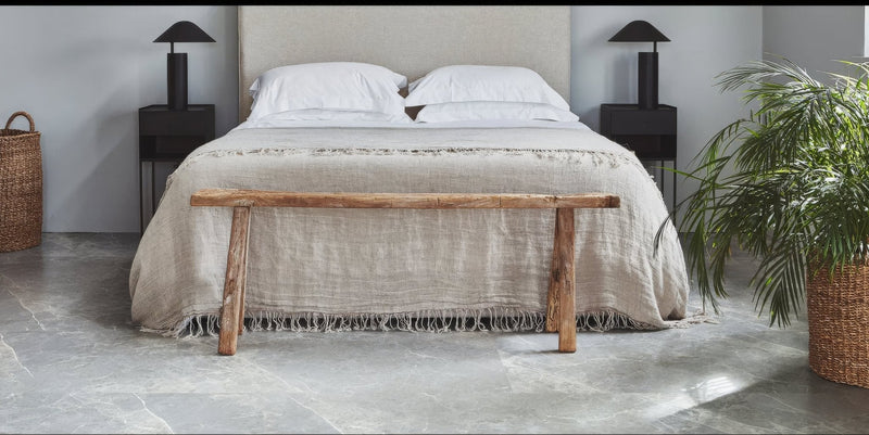 Rustic wooden bench with natural unfinished wood grain and sturdy legs in marble effect vinyl tiles lvt collection