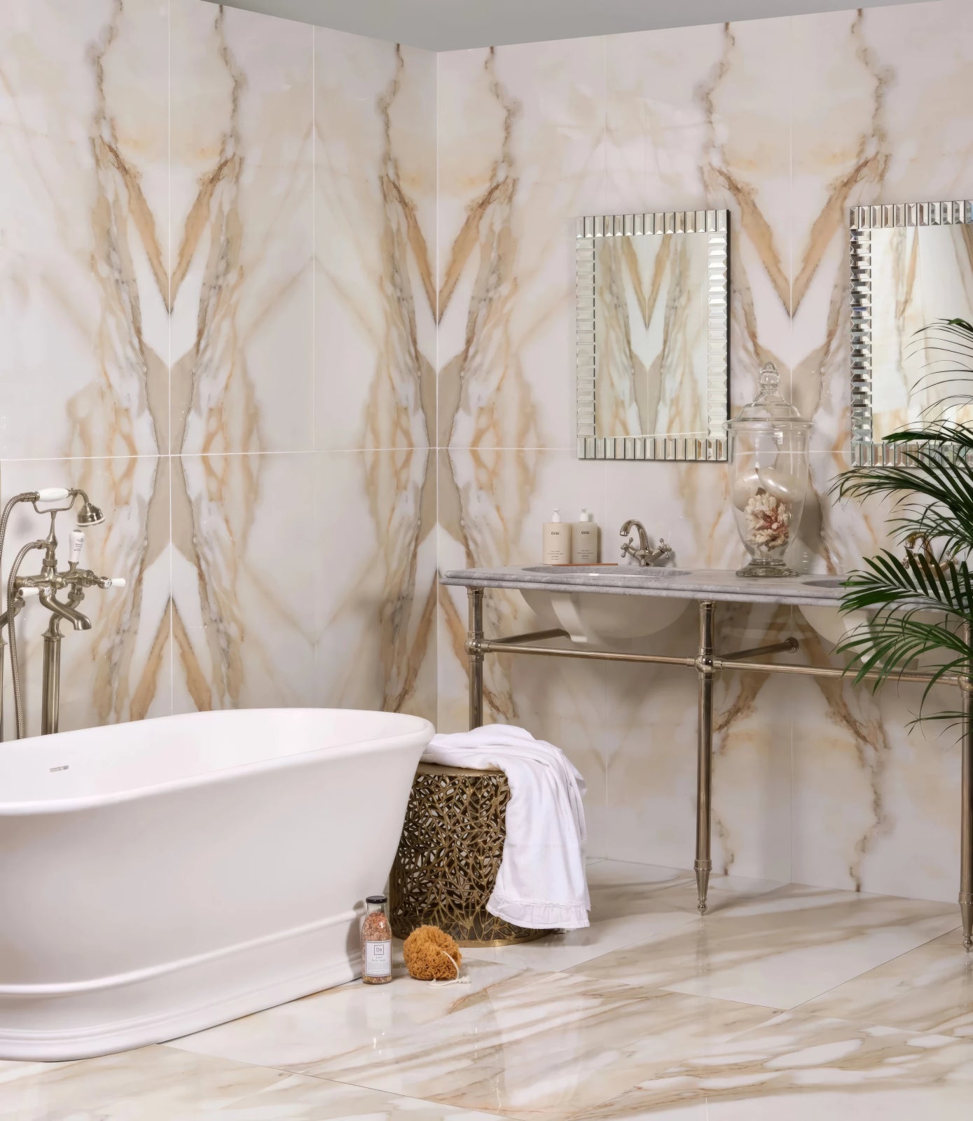 The Portare Collection by Ca Pietra Tiles features cream marble tiles with golden veining in a symmetrical bathroom design.