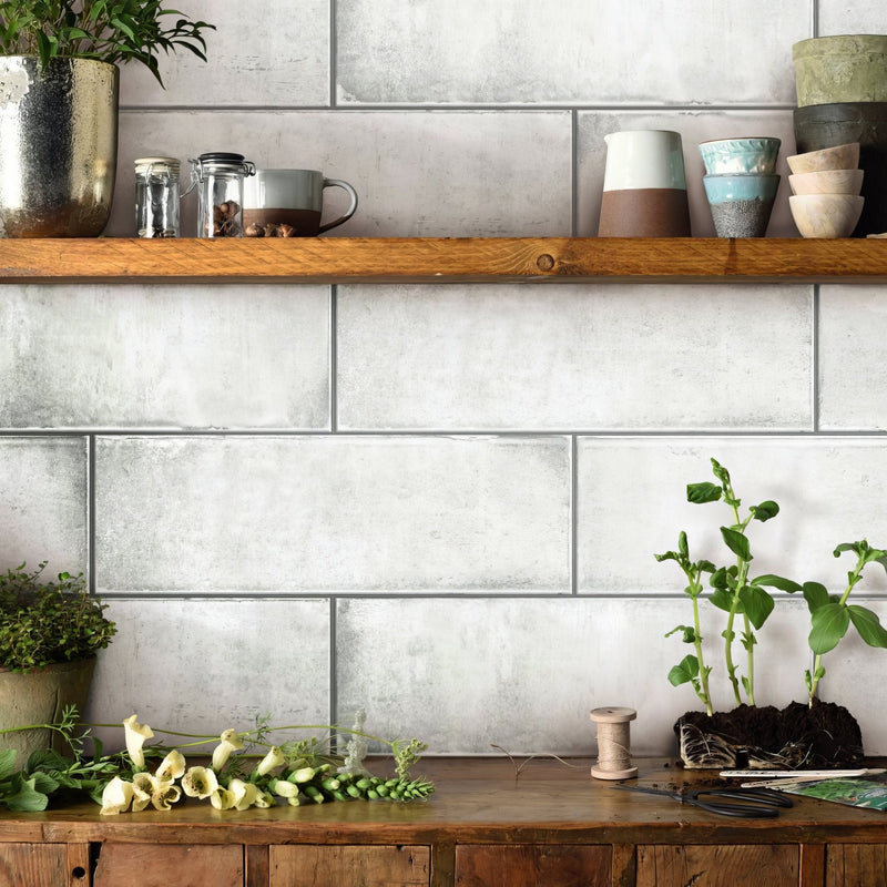 A rustic wooden shelf with natural grain holding ceramic pots and glass jars in the white tiles collection
