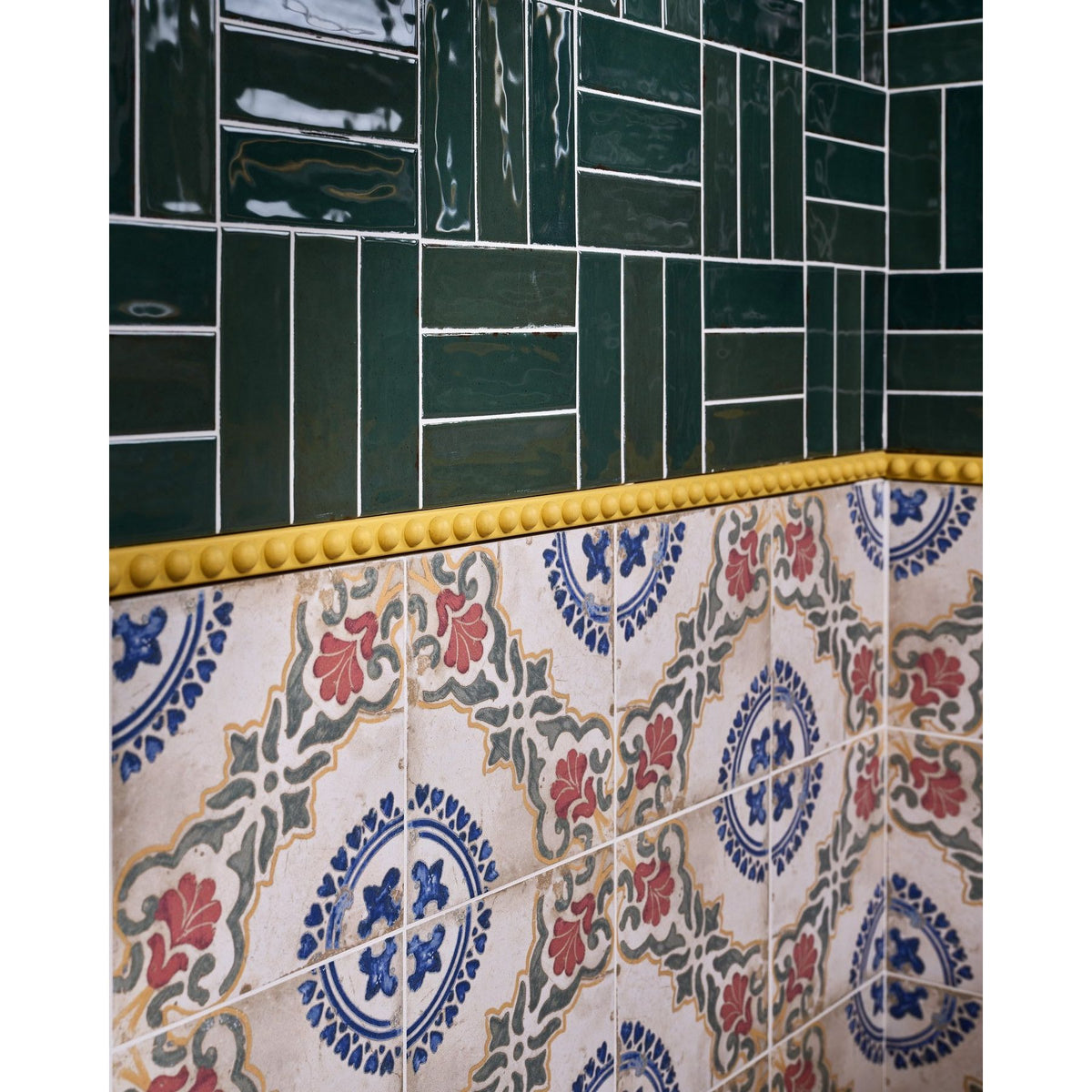 Ca'Pietra Ornamento Composite Trim Bobbin used as a softly scalloped border with green gloss wall tiles