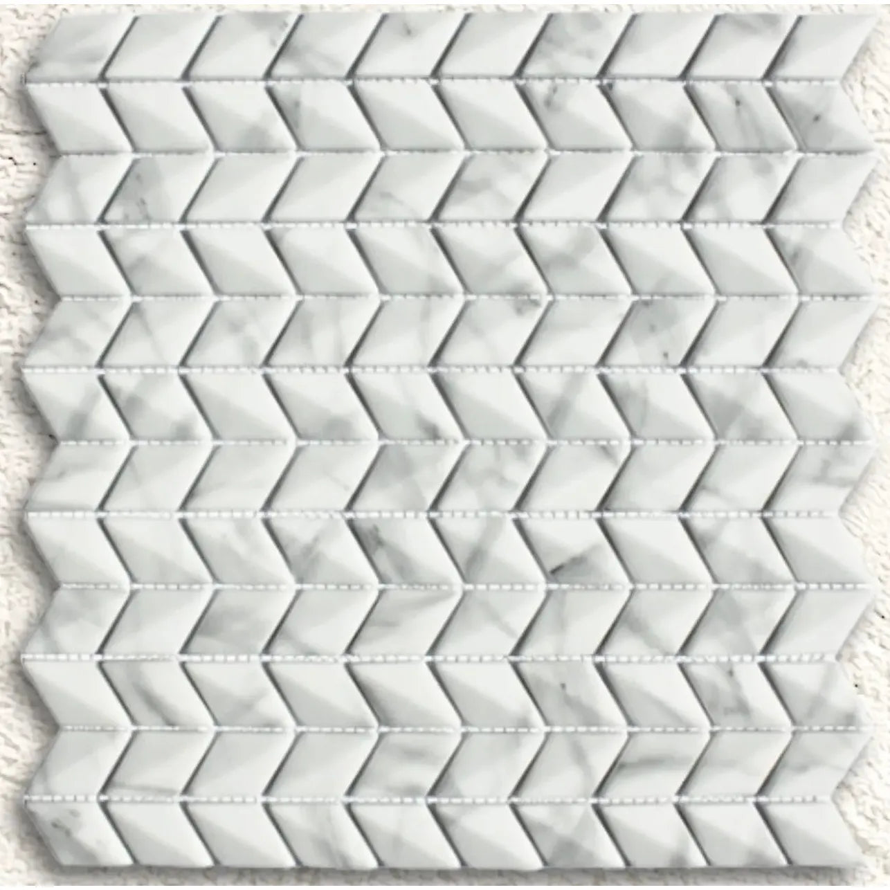 White marble mosaic tile featuring a diamond chevron pattern in ritz carrara for stylish wall or floor decor