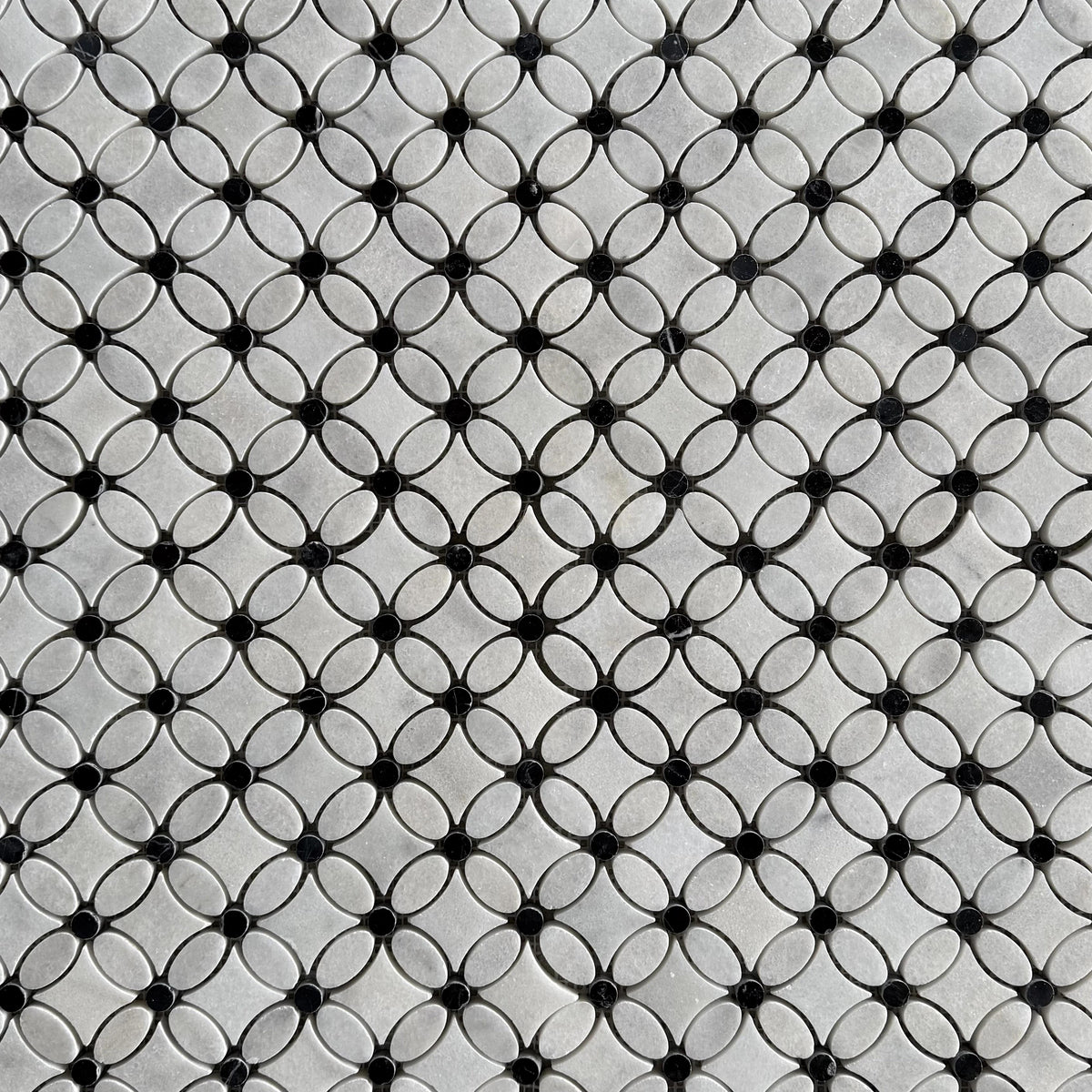Close detail of a single Carrara marble flower with its polished black Nero Marquina centre