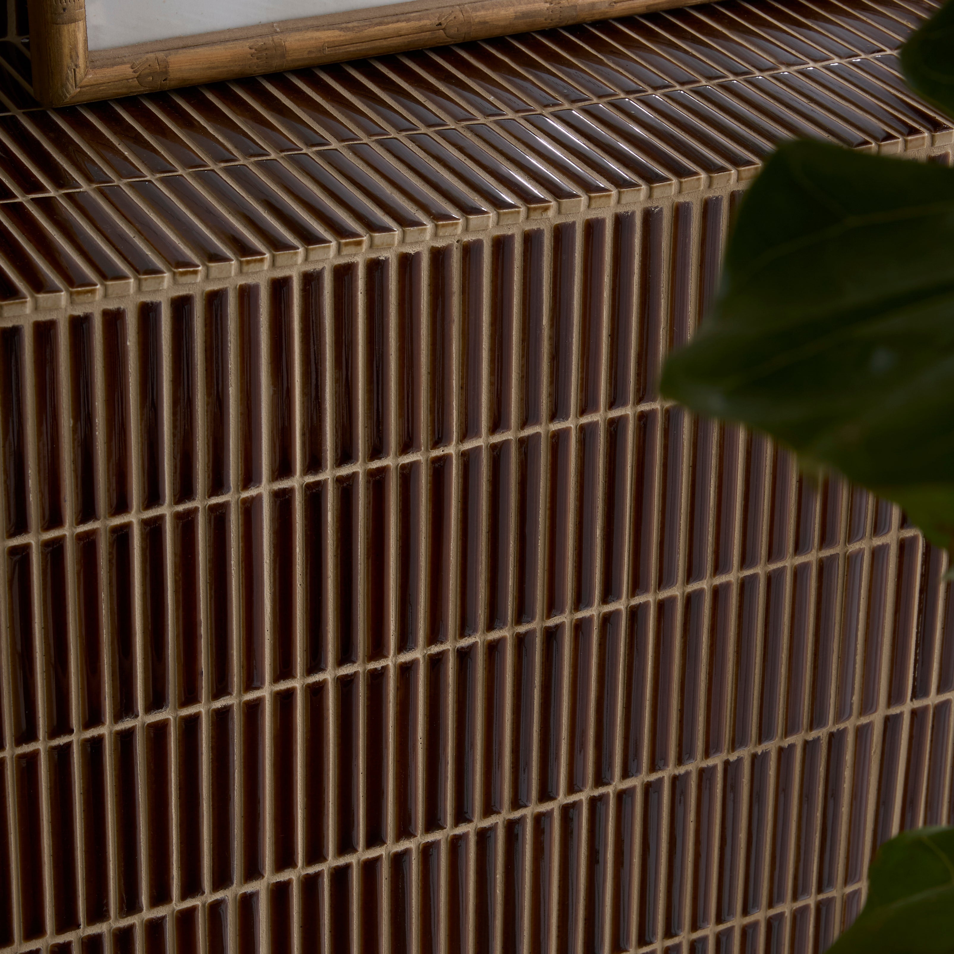 Close-up of a textured surface with a grid pattern and a plant leaf in the corner.