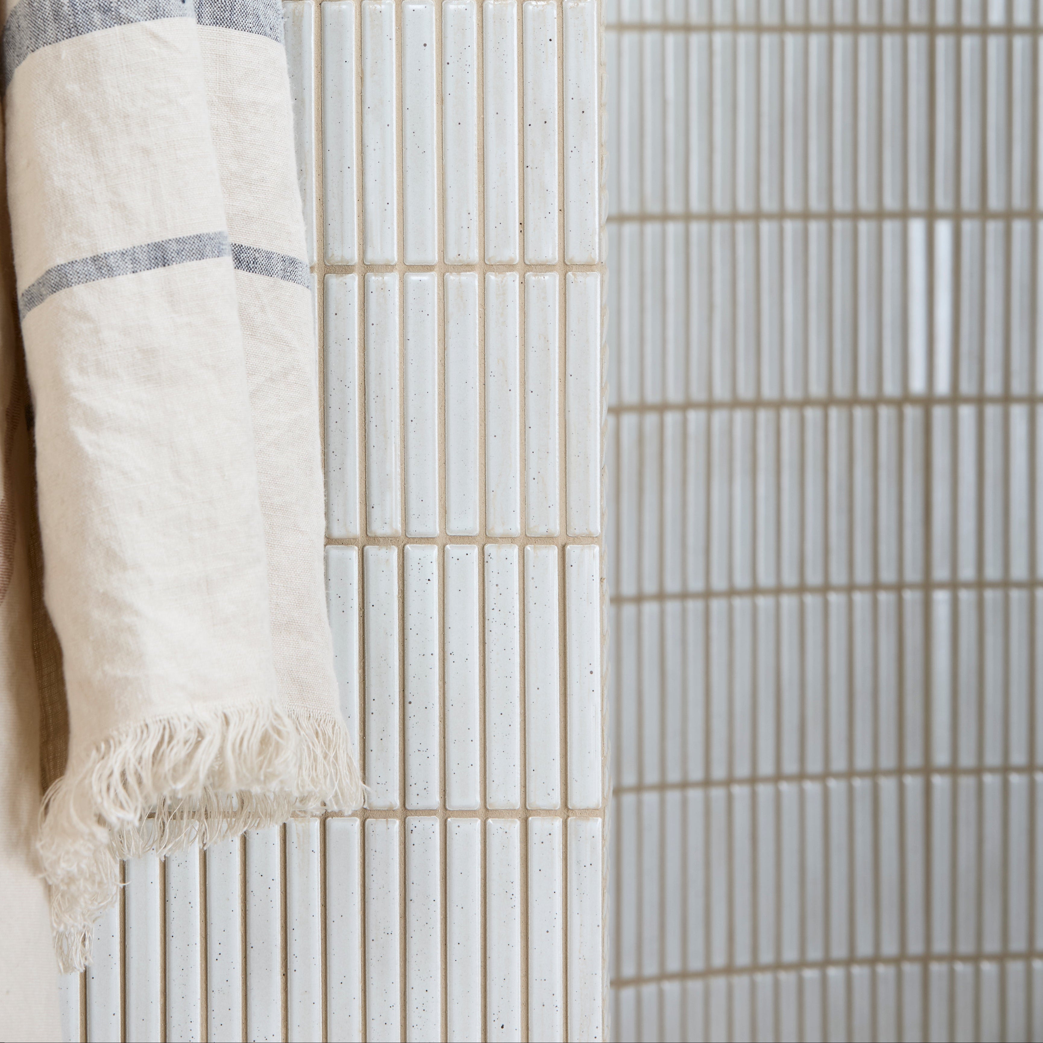 Close-up of a white towel with blue stripes against a striped background