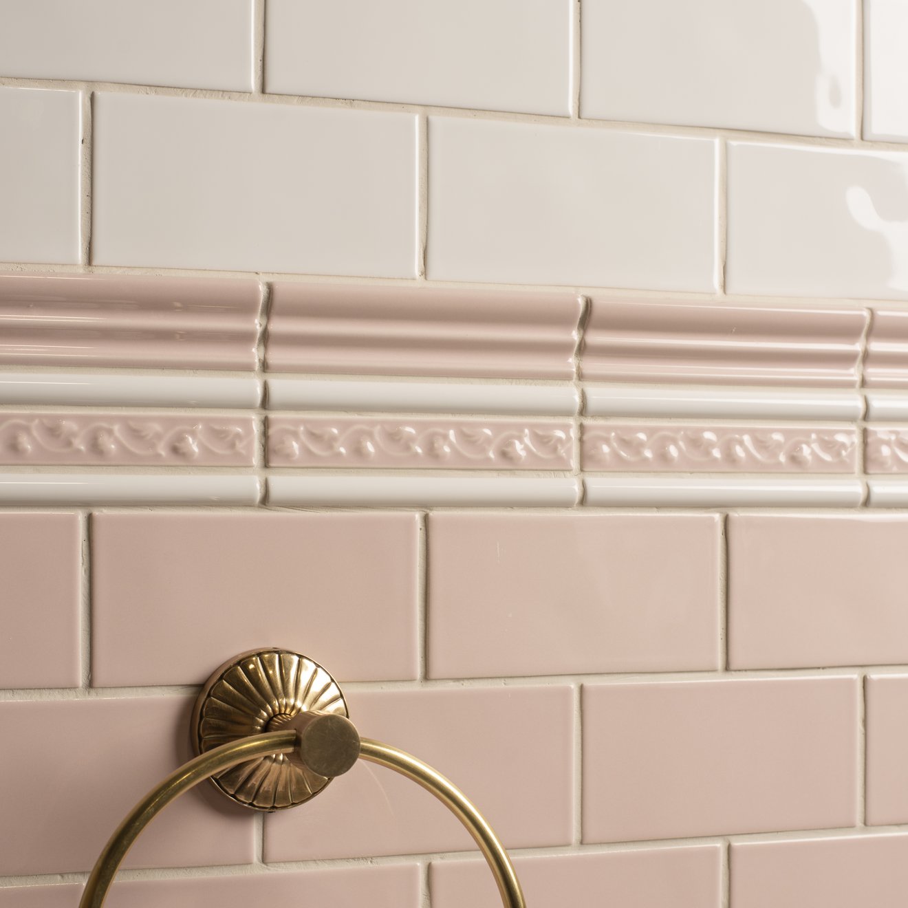 Beaulieu moulding clare brass towel ring with sunburst design mounted on pink tiled walls