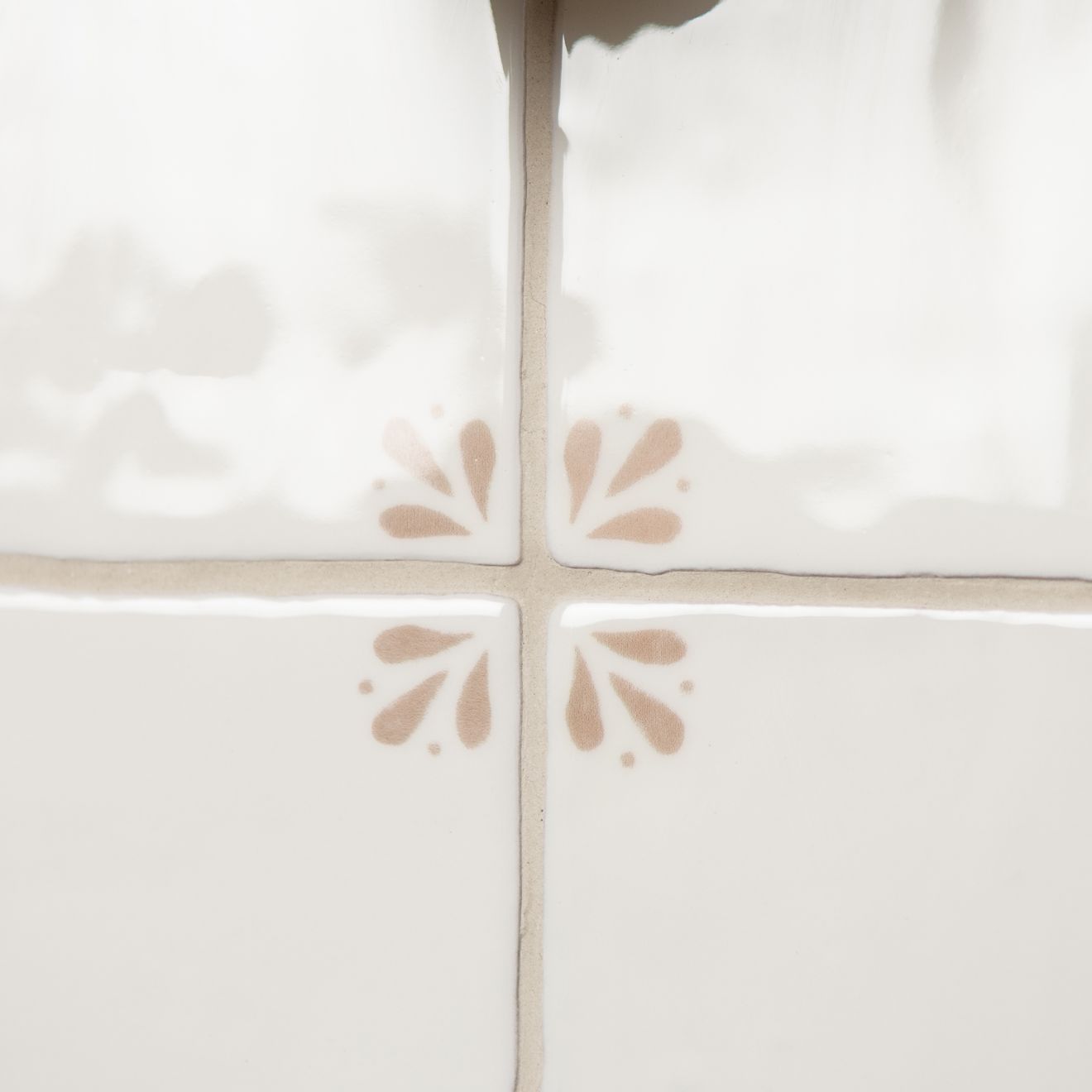 Close-up of white tiles with brown floral patterns
