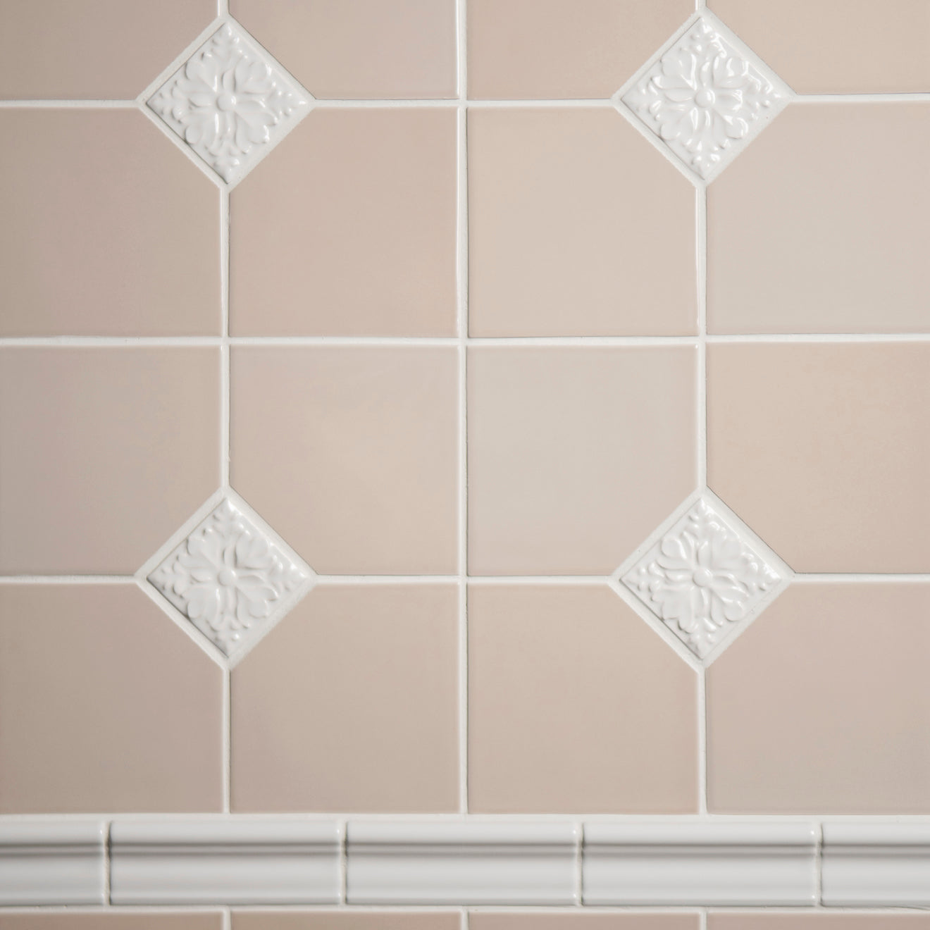 Close-up of beige tiles with decorative white accents