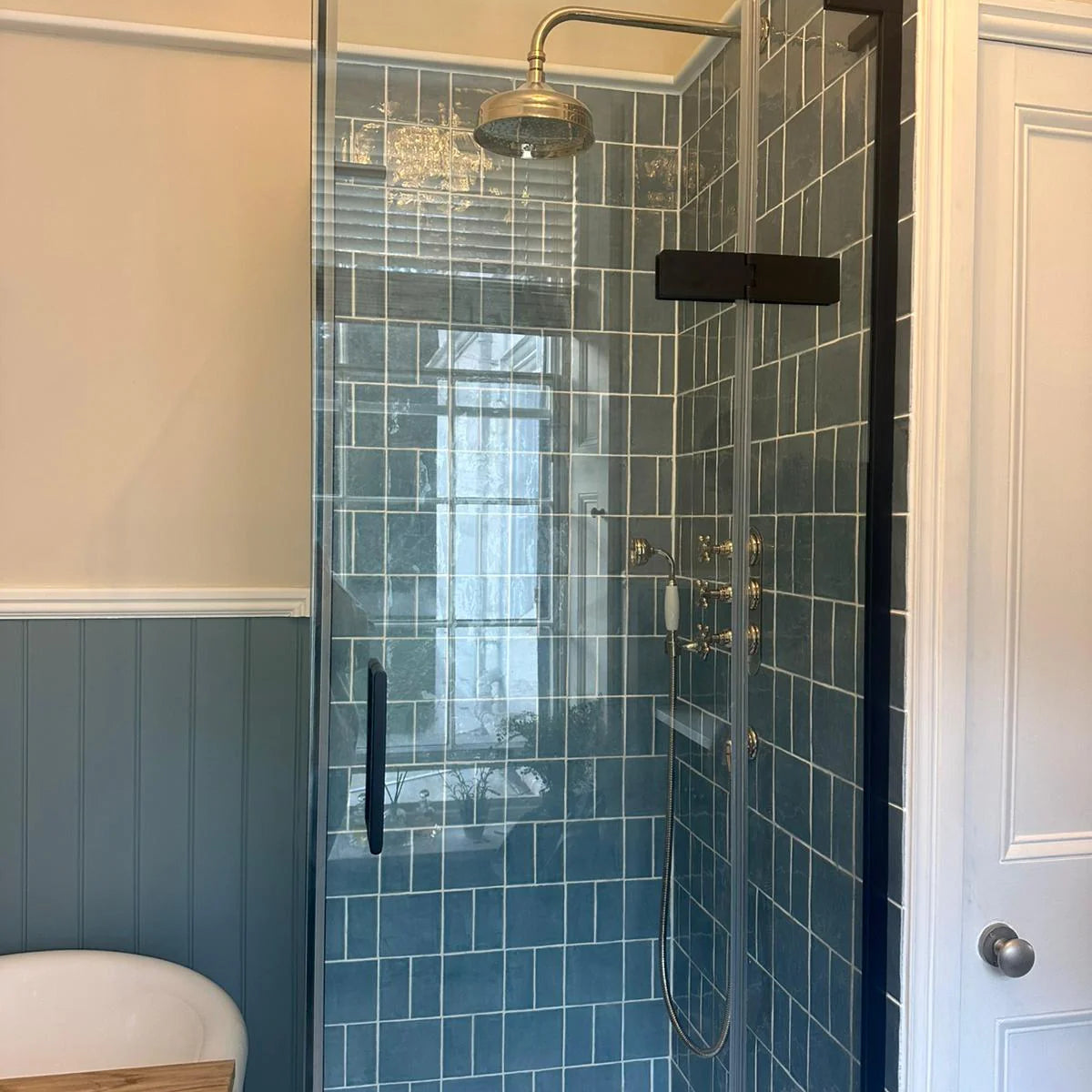 Modern bathroom with a glass-enclosed shower area featuring blue tiles in Jaipur Storm Rectangle Glazed Tile