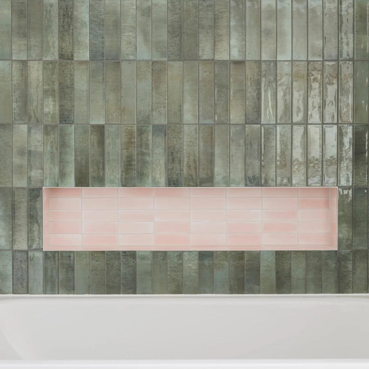 A rectangular pink ceramic tile tray displayed against textured gray green vertical tiles for decor use