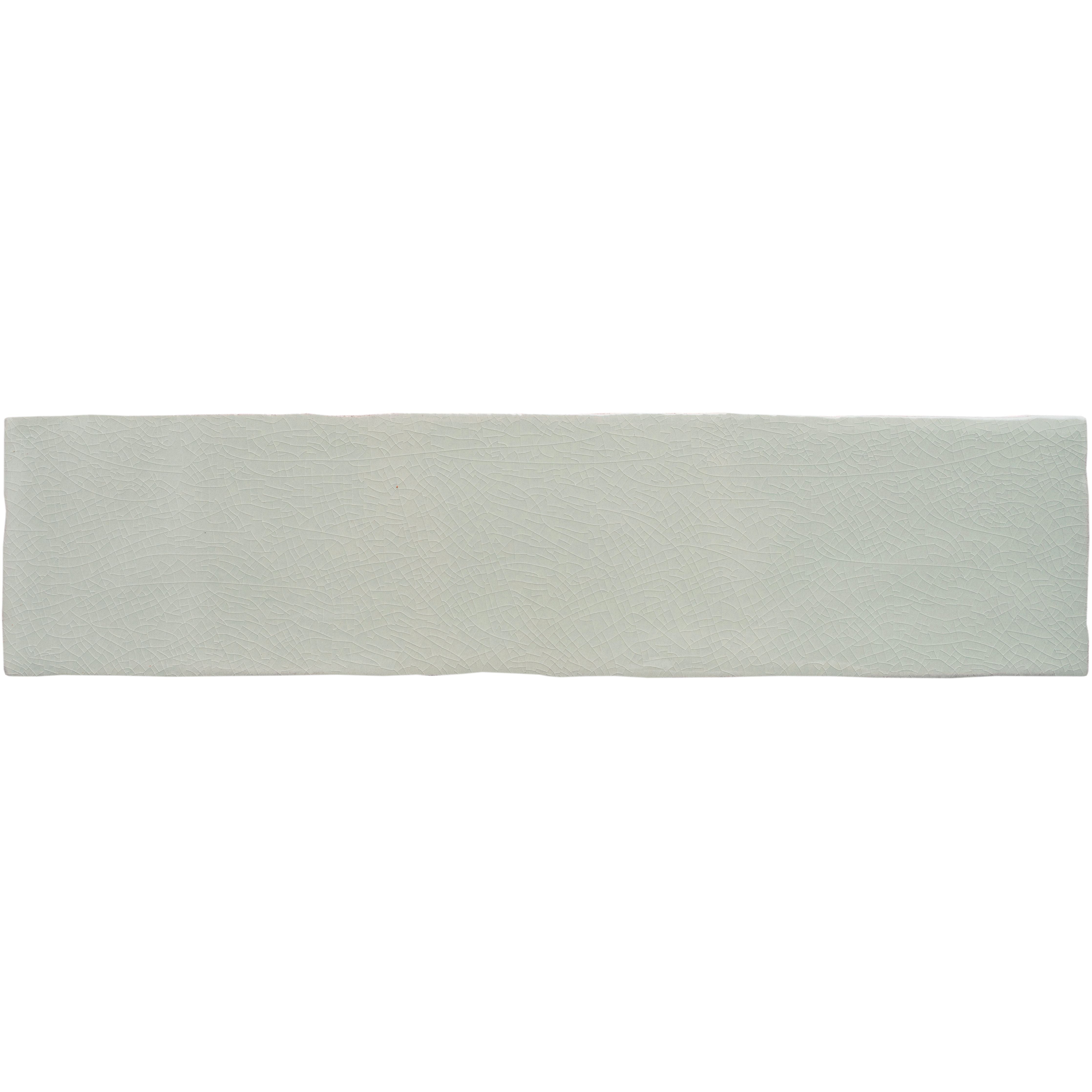 A soft beige towel with white horizontal stripes and fringed edge hangs against muted gray large brick tile tern background