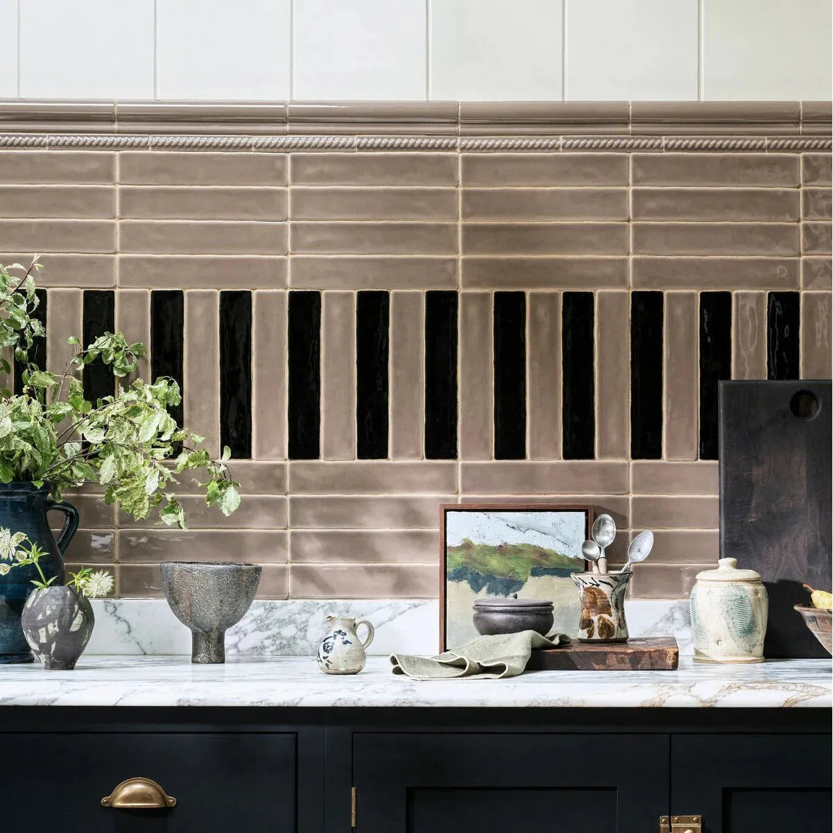Kitchen counter with decorative items against a tiled backsplash