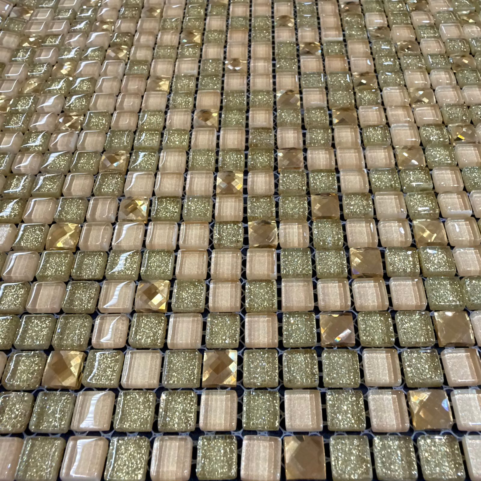 A shimmering svartna sparkling mosaic tile panel with champagne and gold glitter glass squares in a grid pattern
