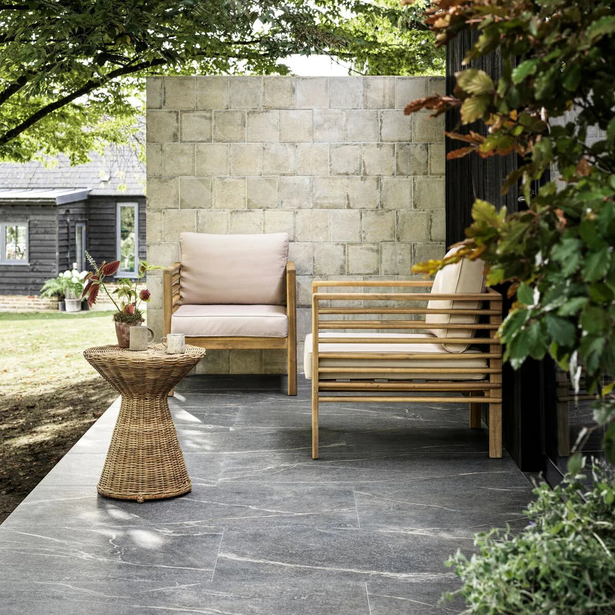 Light wood slat outdoor armchairs with beige cushions on urban taupe plain porcelain tile floor