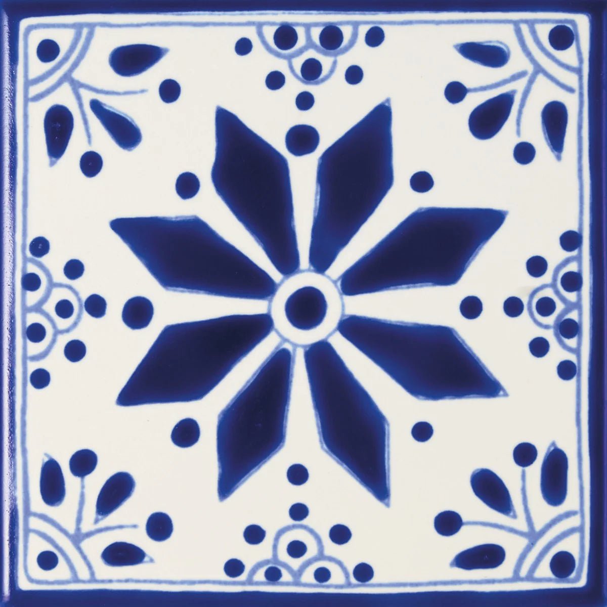Blue and white ceramic tile acapulco zenil 10x10cm with central starburst floral design and decorative leaf motifs