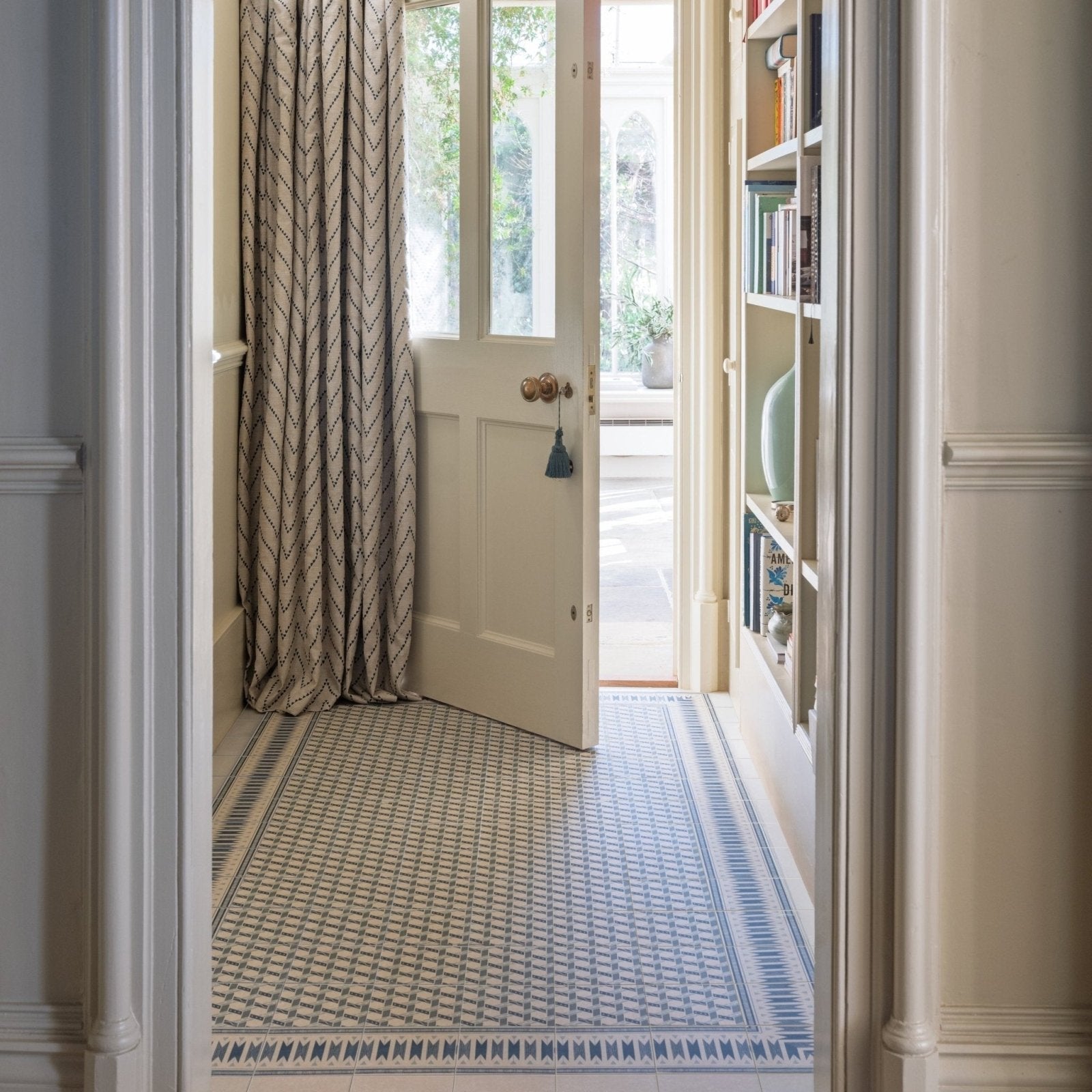 Hallway with adventuras malla blue porcelain tile floor featuring blue and white geometric patterned design