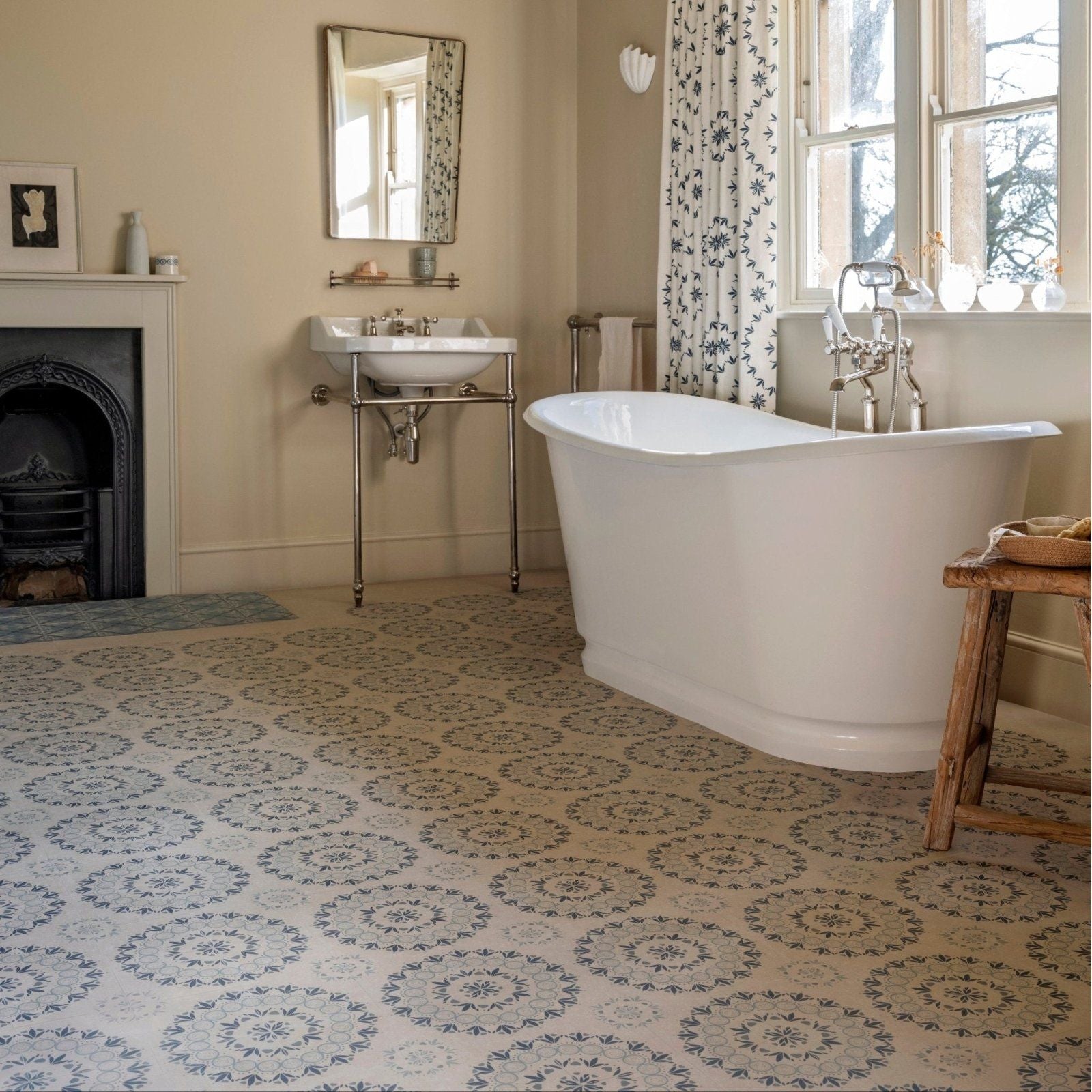 White freestanding bathtub with classic curved design and polished chrome fixtures in Adventuras Palma blue porcelain