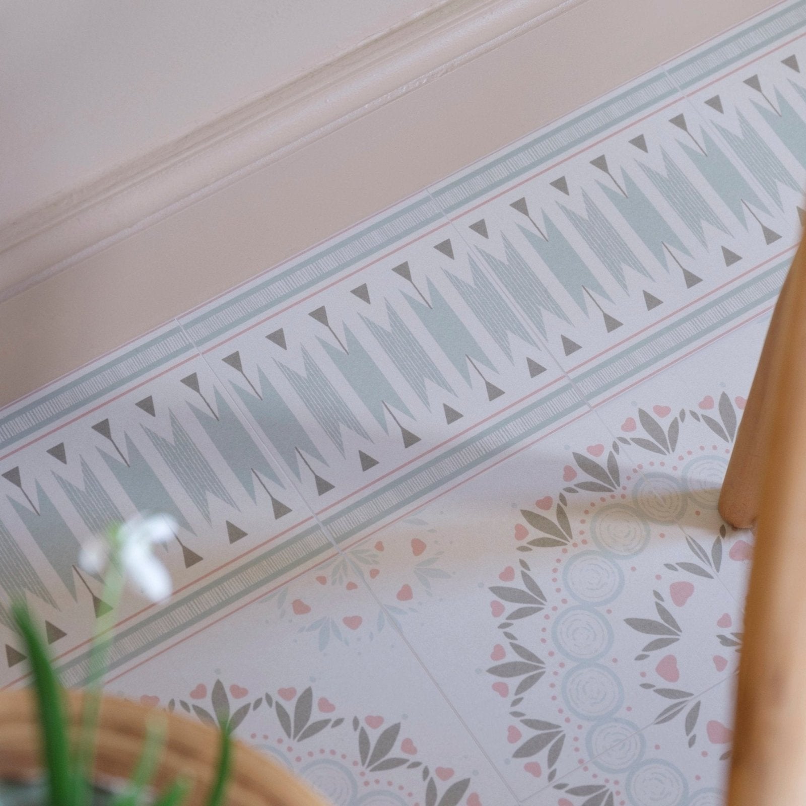 A decorative border of adventuras palma olive porcelain with light gray triangles and dark gray accents on pale blue background
