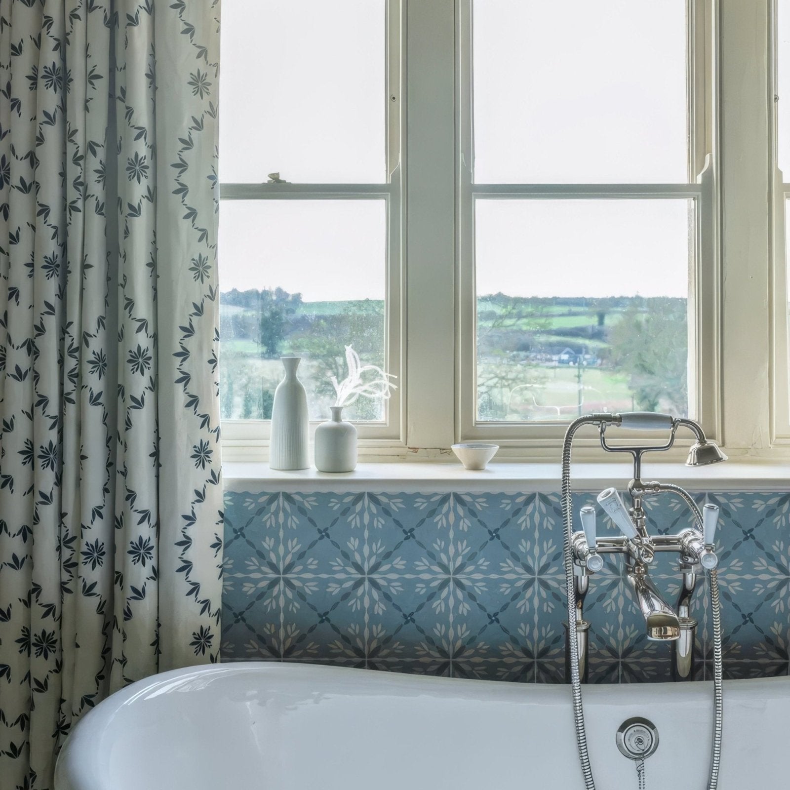White porcelain bathtub with chrome faucet and handles from adventuras porto blue porcelain collection