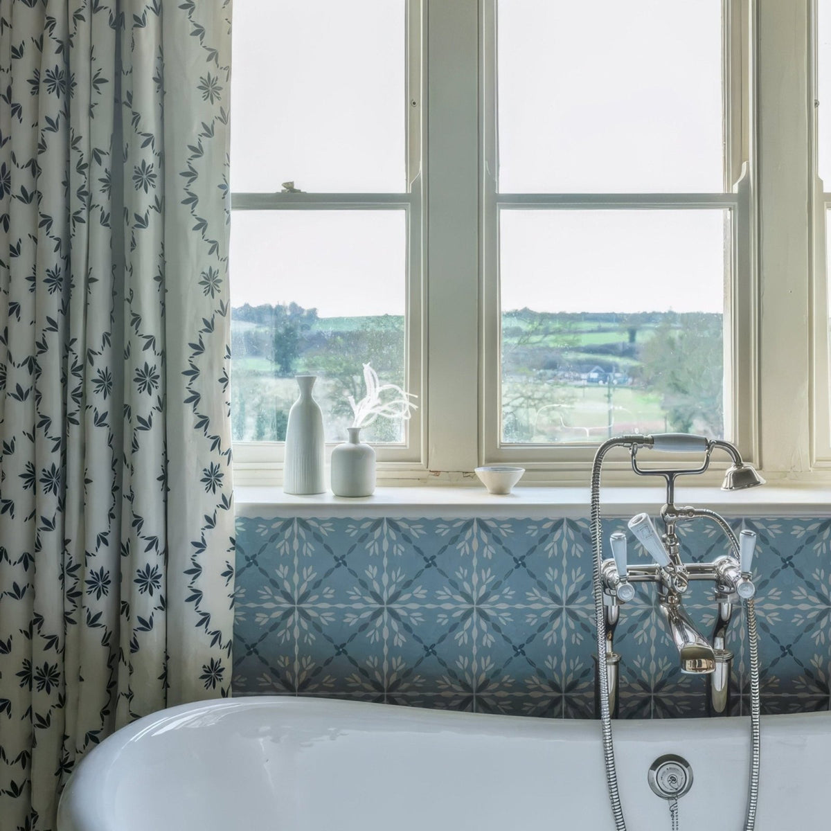White porcelain bathtub with chrome faucet and handles from adventuras porto blue porcelain collection