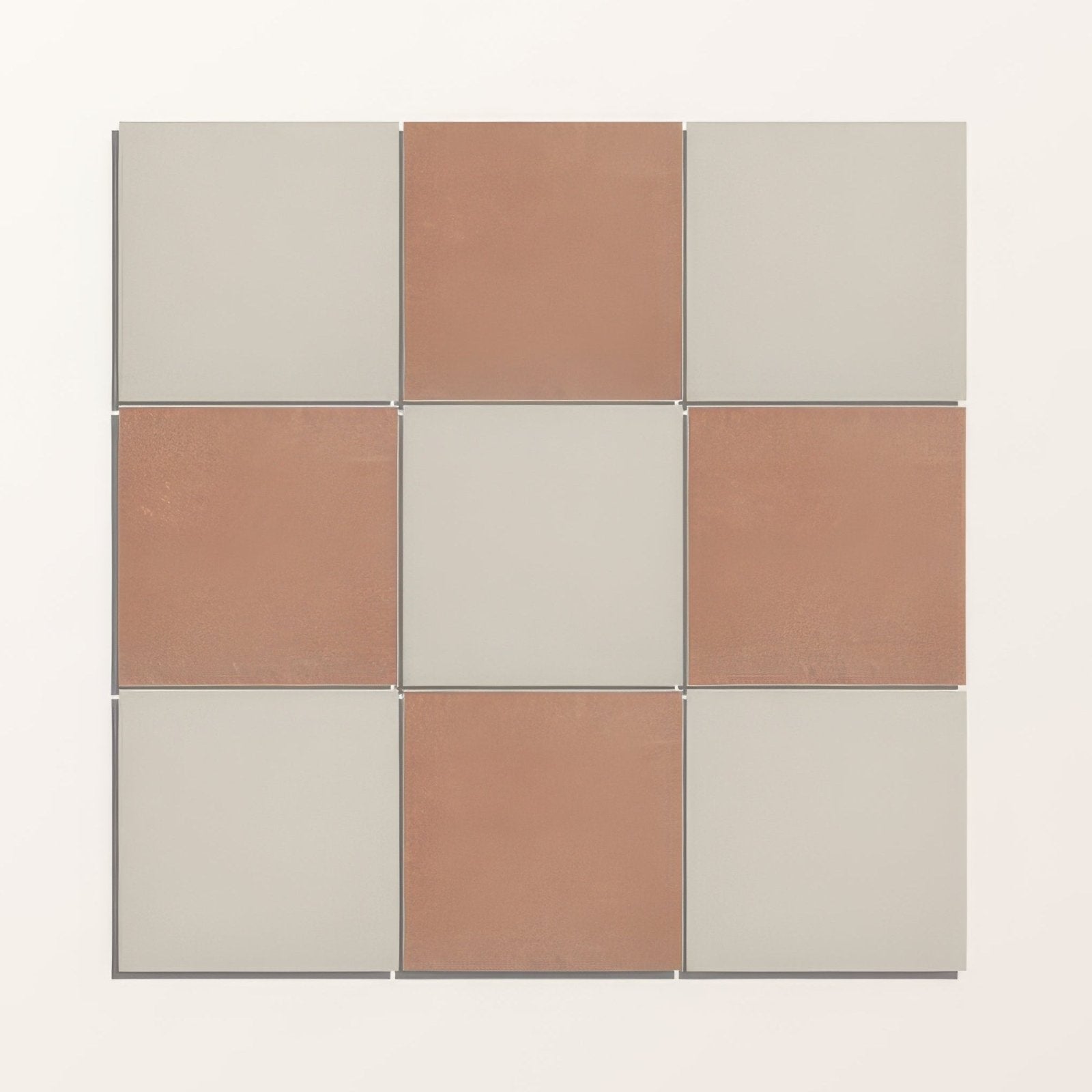 A square mosaic tile arrangement of muted terracotta and soft gray porcelain in adventuras terracotta field style