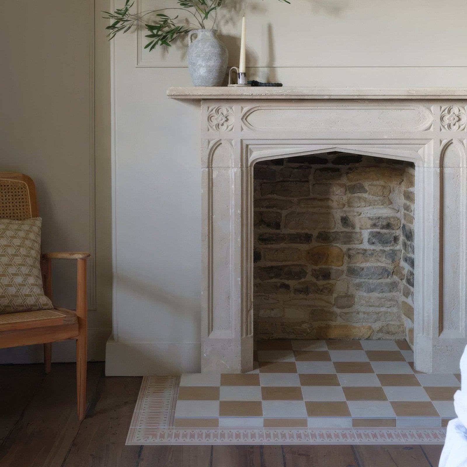 Antique white stone fireplace with ornate carvings and rustic brick interior featuring Adventuras Ziggy Border terracotta porcelain