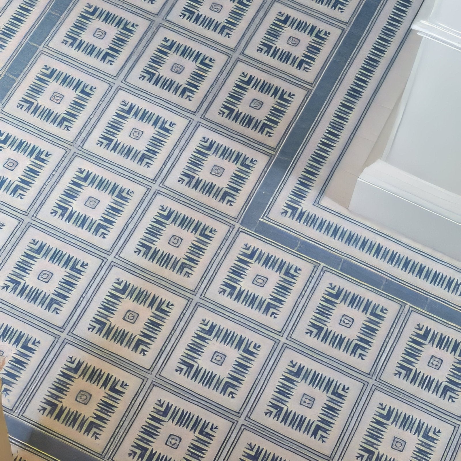 Blue and white geometric patterned porcelain floor tiles with a repeating diamond design from adventuras ziggy corner blue