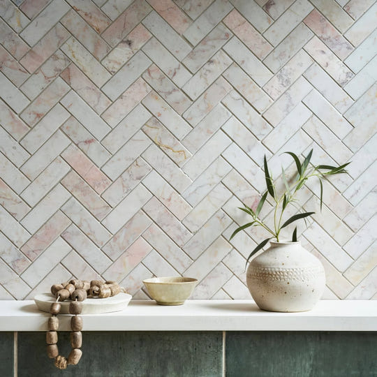 Aegean Pink Herringbone Marble Mosaic pink marble herringbone mosaic styled with an off-white ceramic vase