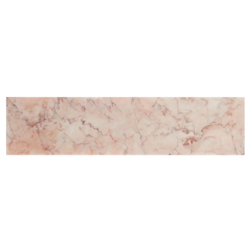 A rectangular pink marble tile with subtle rose gold veining aegan pink marble 7.5 x 30.5cm