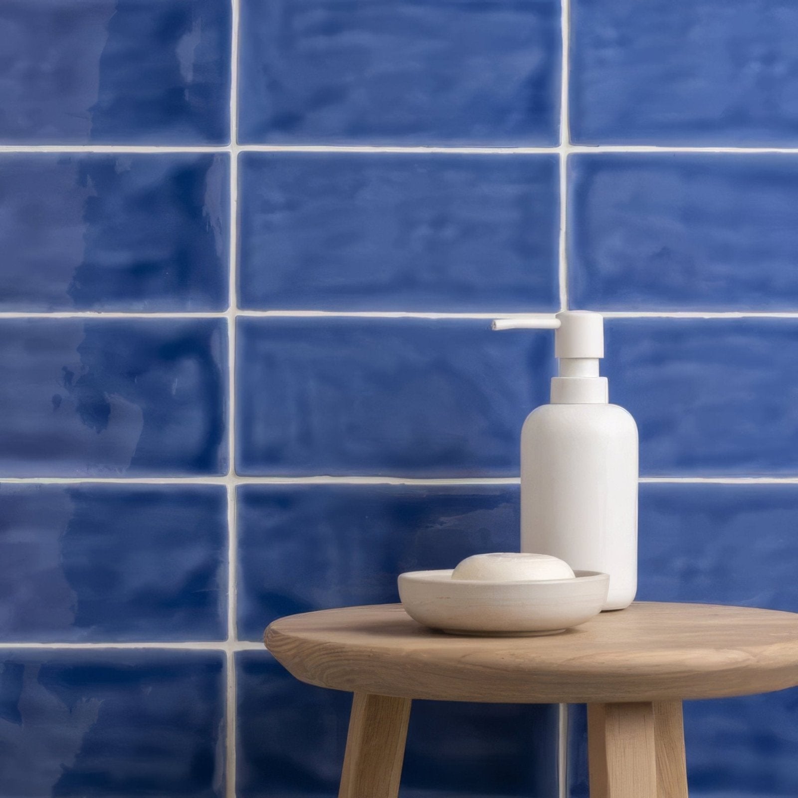 White ceramic soap dispenser with sleek minimalist design featured in agapanthus brick tile setting