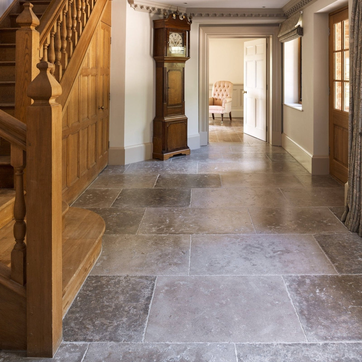 Dark grey Aquitaine limestone tiles with a polished seasoned finish and slightly uneven surface covering the floor
