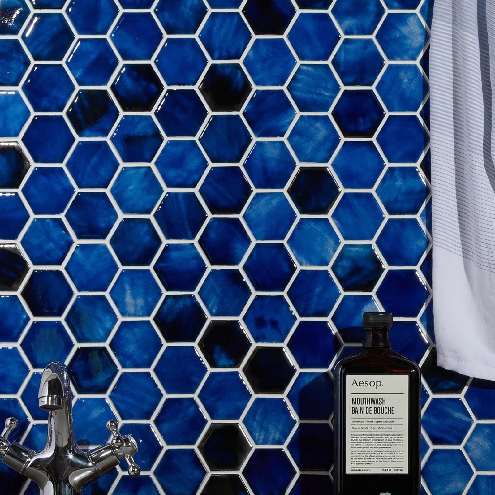 Akazu Porcelain Cobalt Mosaic deep blue hexagonal porcelain mosaic tiles styled with a glass bottle