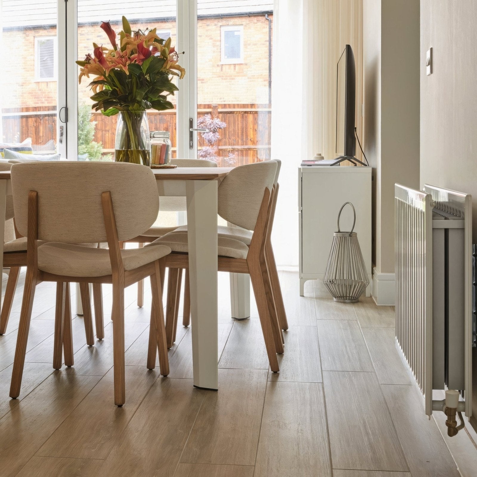 Beige upholstered dining chairs with light wood legs and modern minimalist design paired with alamo ash rectified glazed matt porcelain flooring