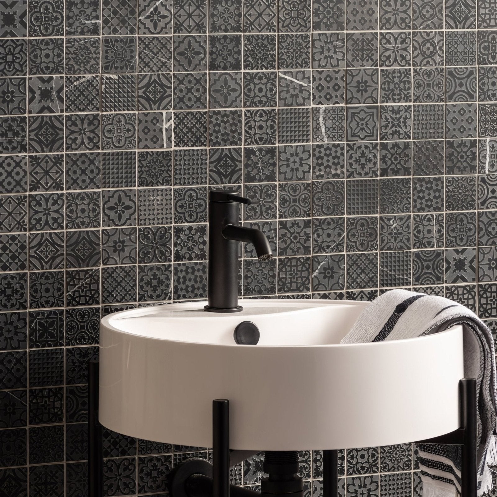 Alto Black Marble Patterned Mosaic black patterned marble mosaic shown behind a white sink with a black tap