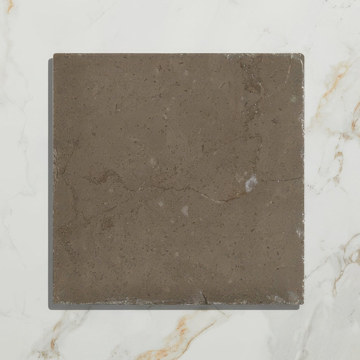A square dark gray amaya limestone tumbled cabochon with natural veining and slightly rough texture