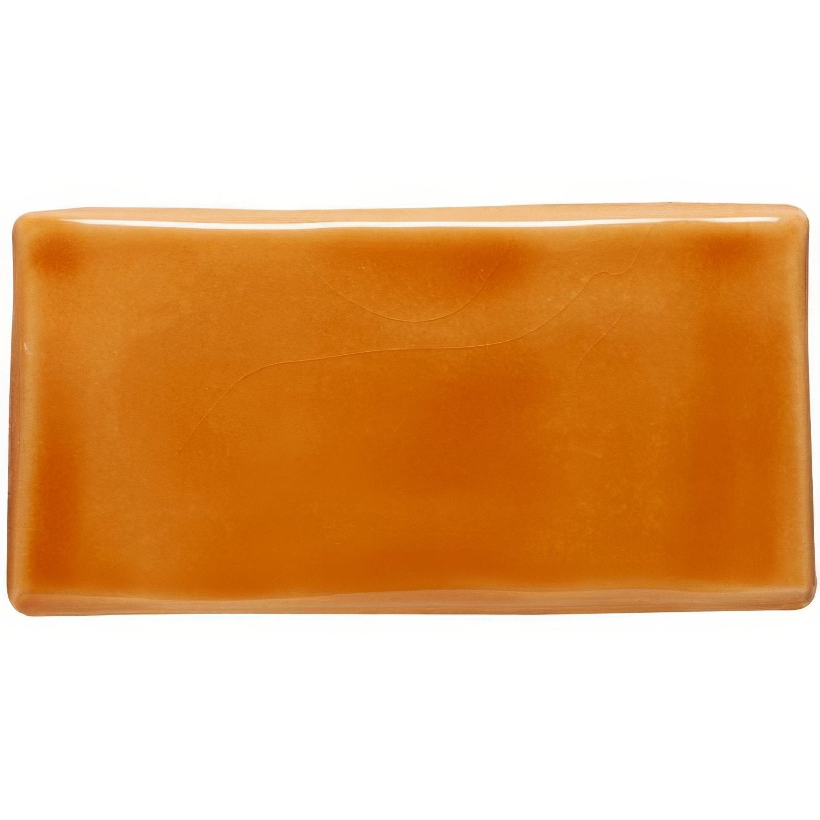 A rectangular glossy amber-colored bar soap with smooth rounded edges called amber half tile