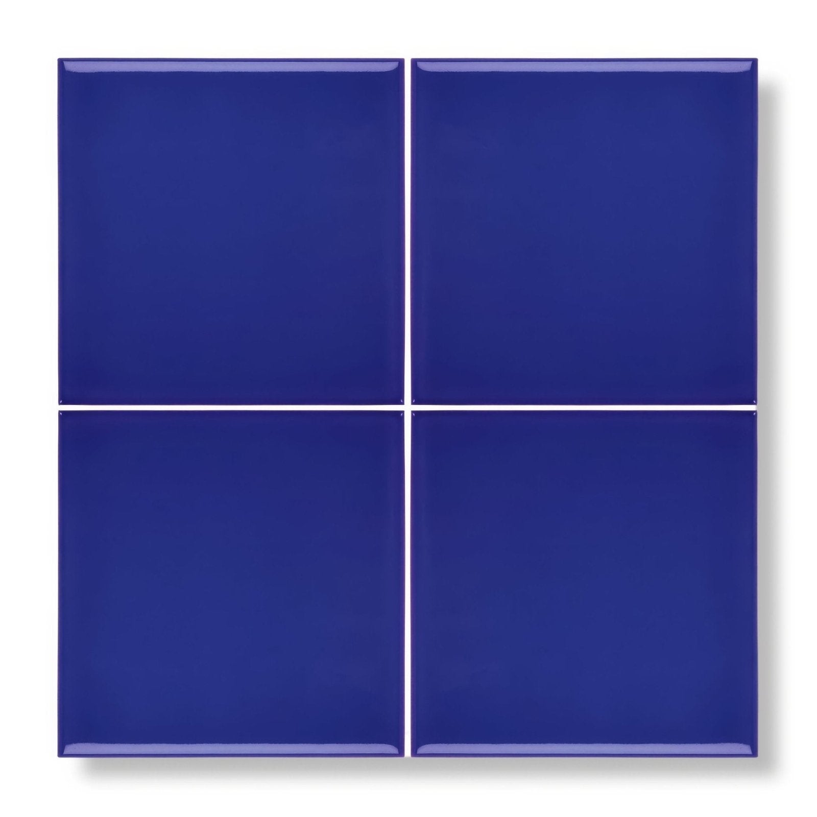 Four glossy royal blue square ceramic tiles arranged in a grid from the andalucia blue glazed tile collection