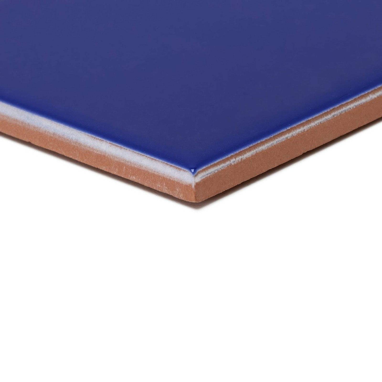 Andalucia blue glazed tile featuring a glossy royal blue ceramic surface with a terracotta-colored edge