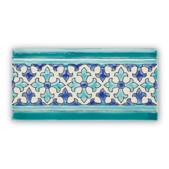 A rectangular ceramic tile from andalucia morena patterned border with white center and blue teal fleur de lis design