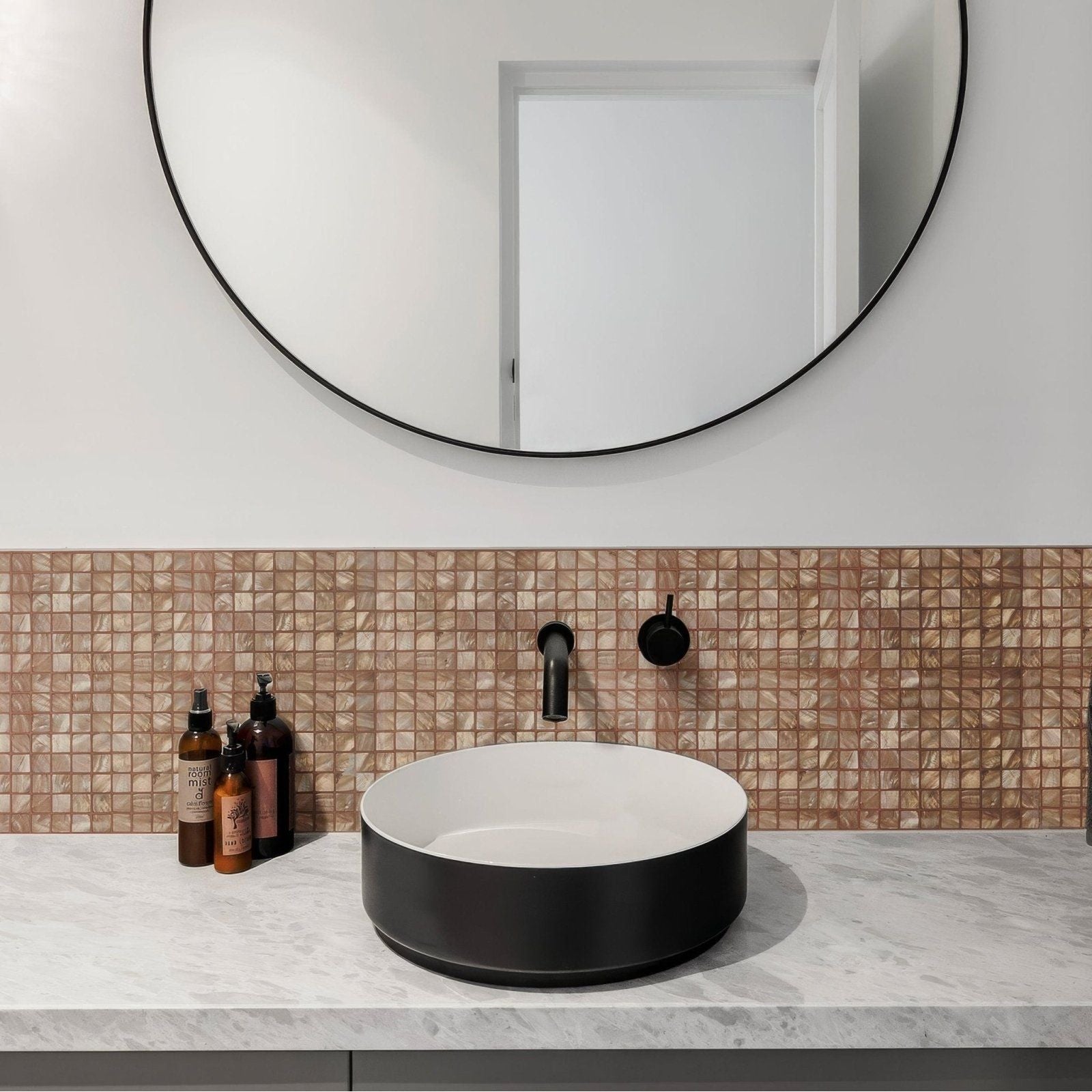 Black ceramic vessel sink with matte finish and rounded edges paired with antique brass 25mm square faucet