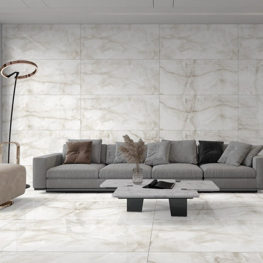 Aquarius Onyx Grey 60 x 120cm white and grey marble-effect tiles with a grey sectional sofa and coffee table