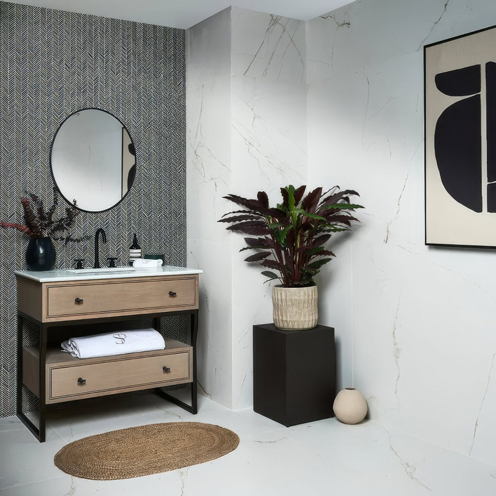 A potted plant with deep burgundy leaves in a textured beige ceramic pot alongside athens amazon marble mosaic tiles