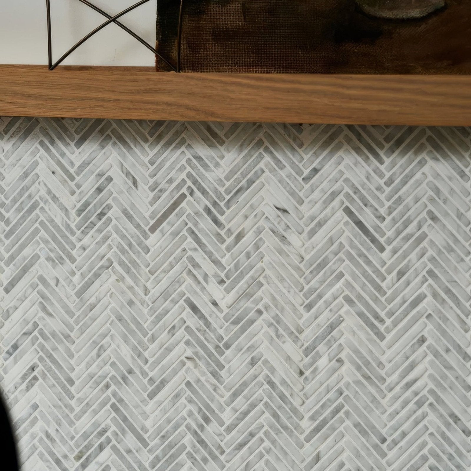 White marble mosaic tile in a herringbone pattern made from athens carrara marble for decorative wall use