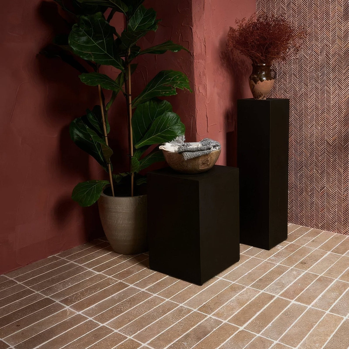 Athens Rosso Travertine Mosaic reddish-brown travertine herringbone mosaic styled with a terracotta bowl of folded fabric